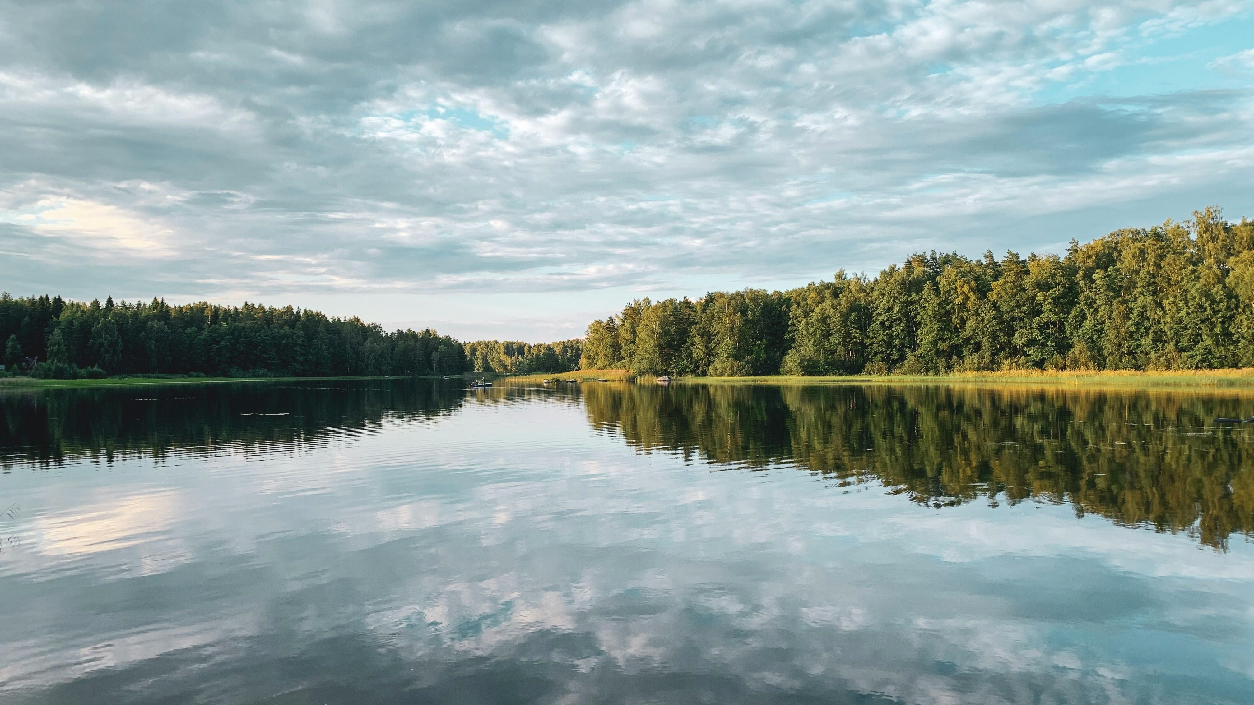 green trees beside river under cloudy sky during daytime by Anna Tsareva courtesy of Unsplash.